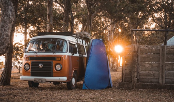 Kombi no acampamento ao pôr do sol